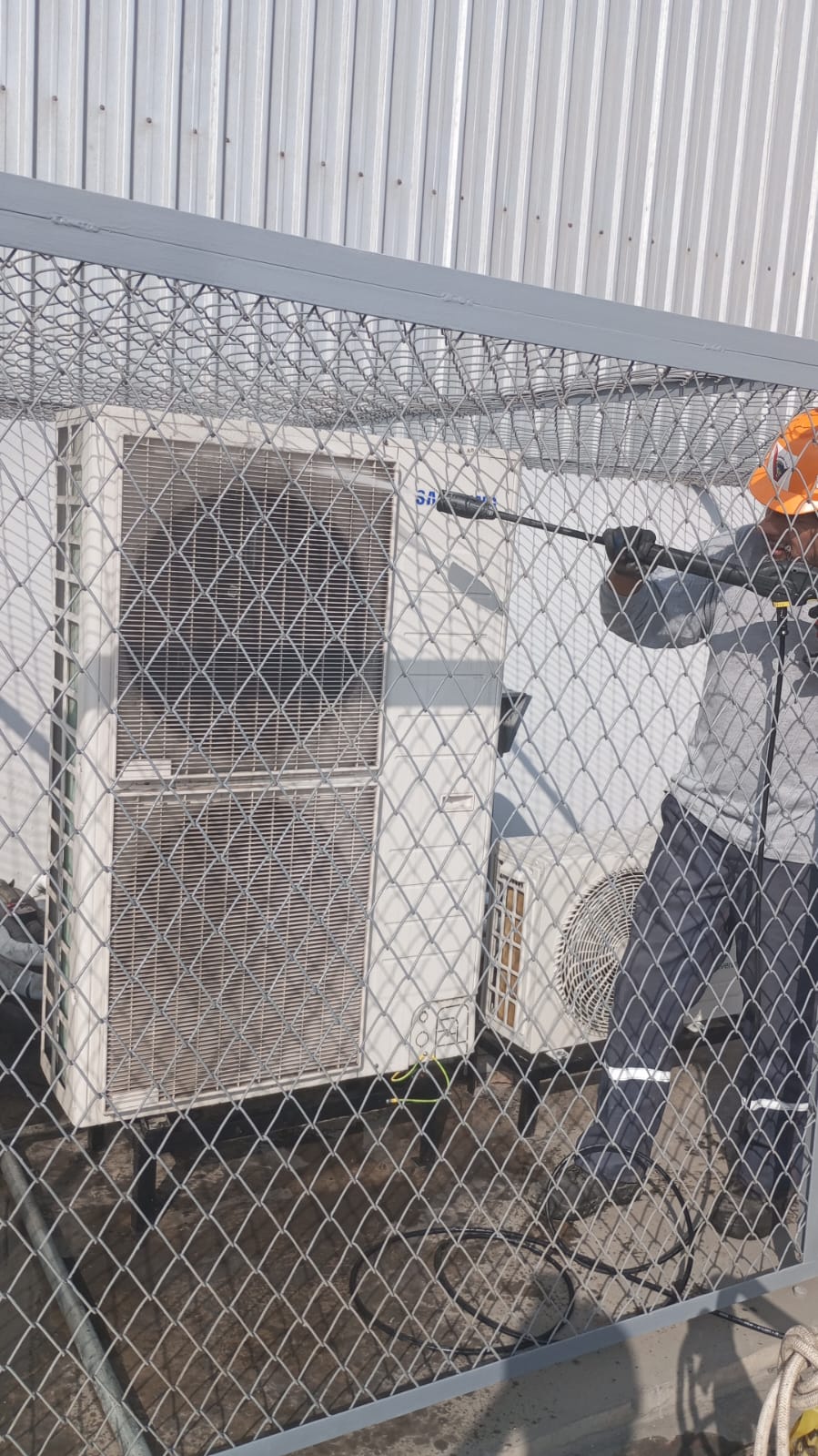 Una persona reparando un Aire Acondicionado